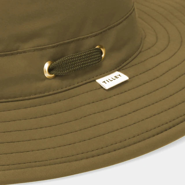 Close-up of a green bucket hat with a brand logo on a white background