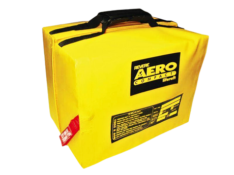 Bright yellow emergency bag labeled "Revere Aero Compact Liferaft" with black handles and a red safety tag, signifying preparedness and safety.